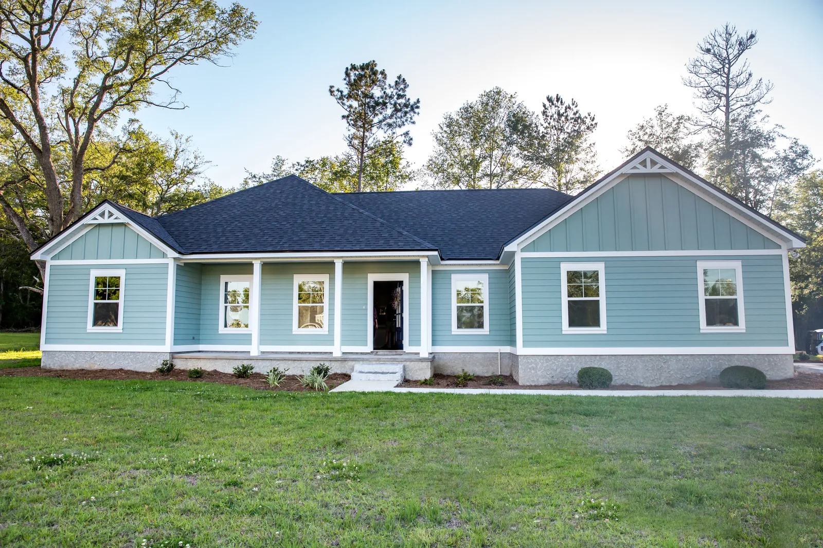 Dark asphalt shingle roof and front porch on a light blue home